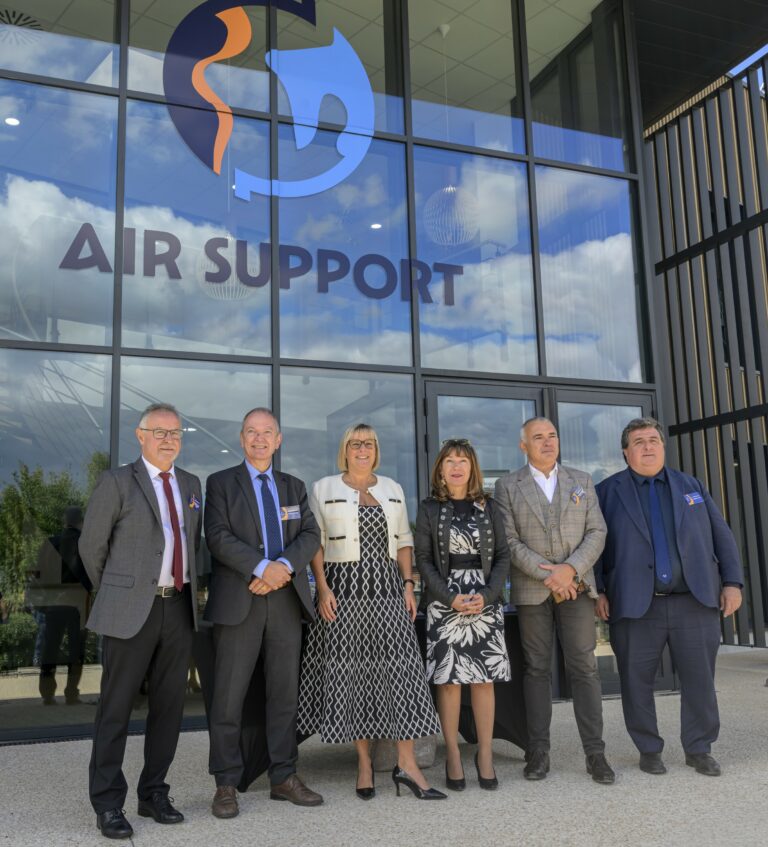 Sabine Tertre et les officiels réunis devant la verrière et le logo d'Air Support lors de l'inauguration des nouveaux locaux à Pujaudran.