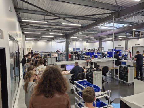 Visite d'un groupe d'élèves et de jeunes dans l'atelier mécanique de l'entreprise Air Support lors de la Semaine de l'Industrie, observant les techniciens travaillant sur leurs postes de travail.