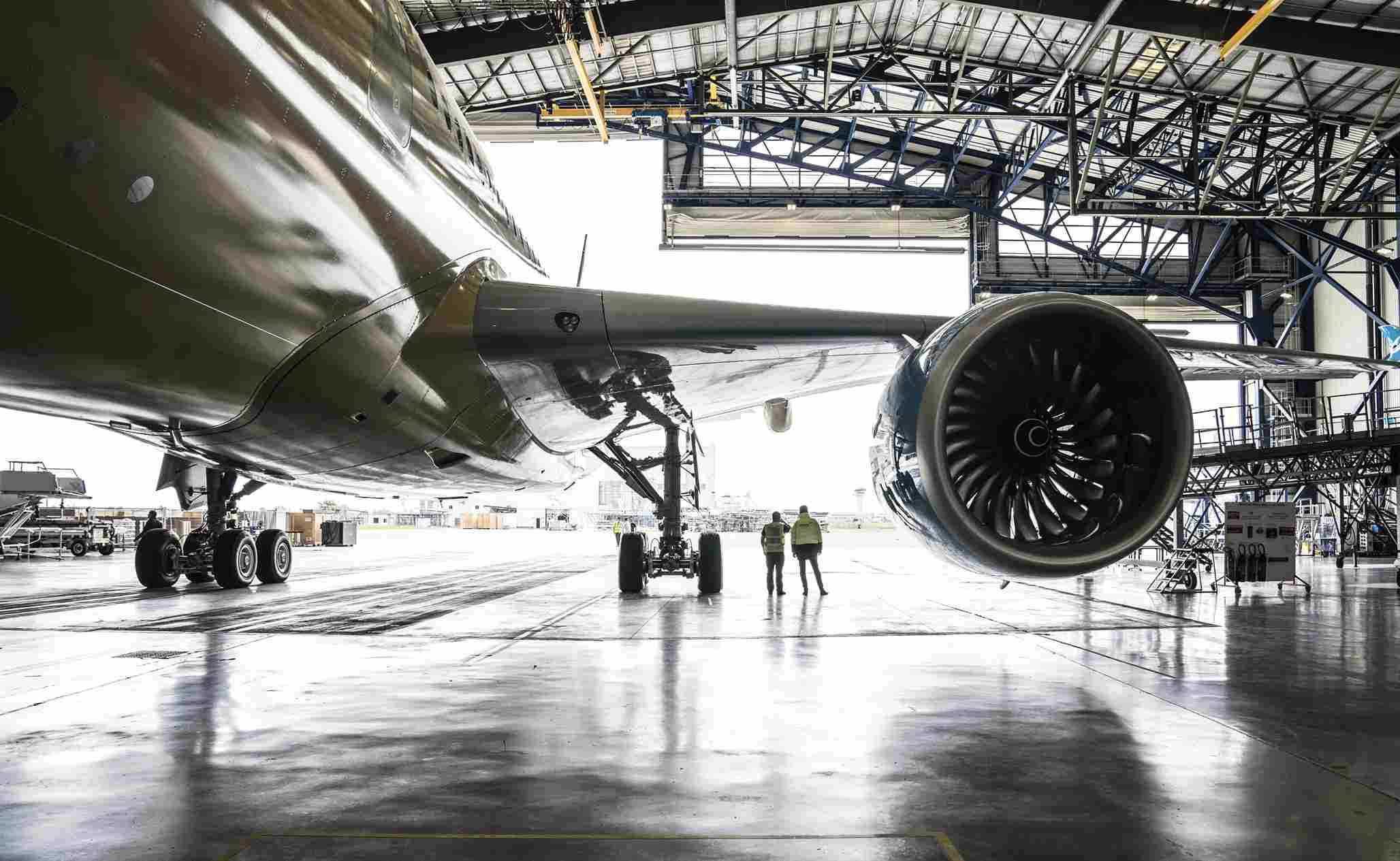 Wide-body commercial aircraft undergoing maintenance inside an aviation hangar