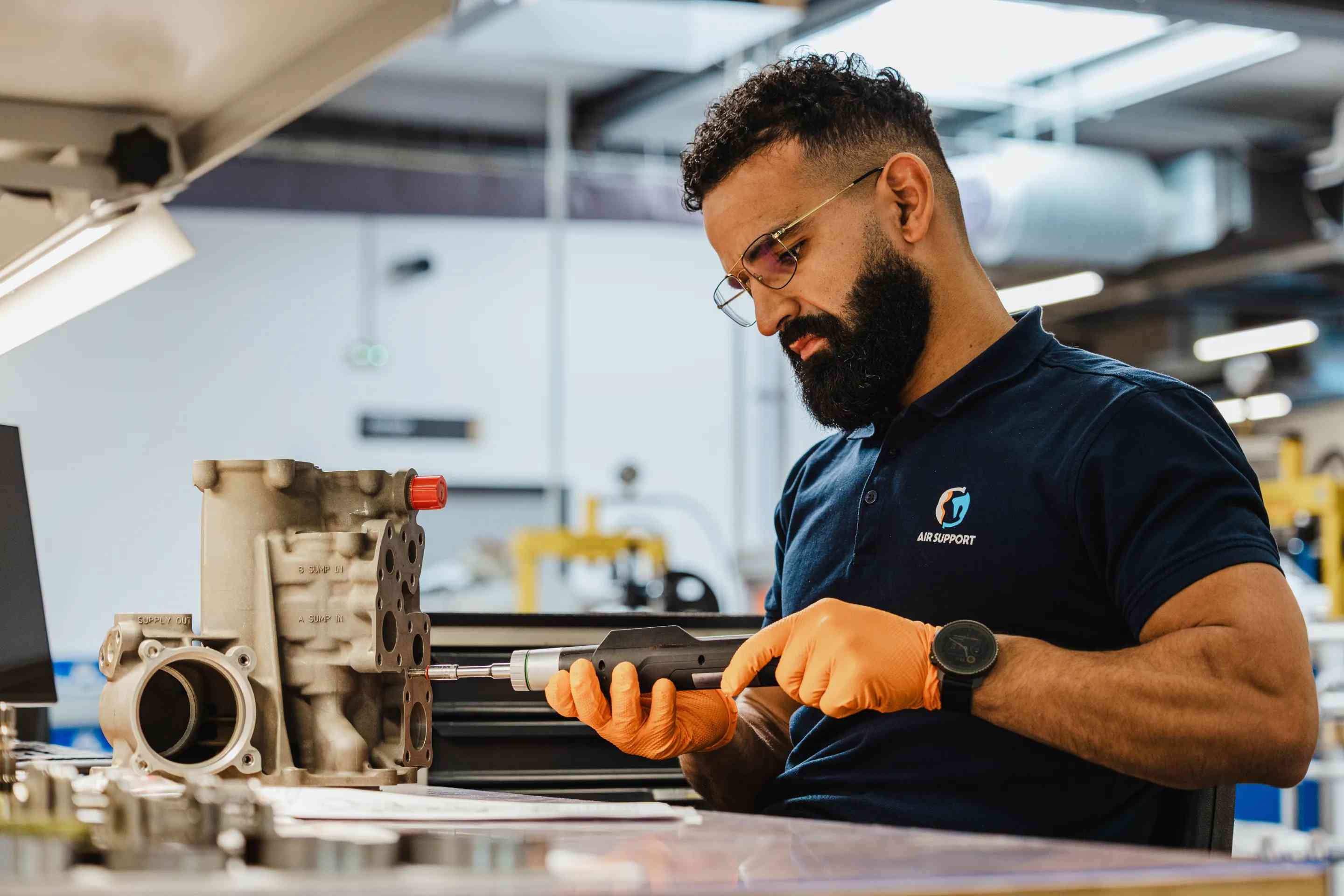 Air Support technician inspecting an aircraft oil system component
